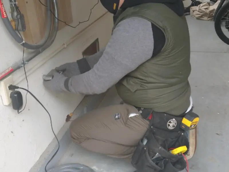 Electrician performing outlet wiring in a Woodhaven garage
